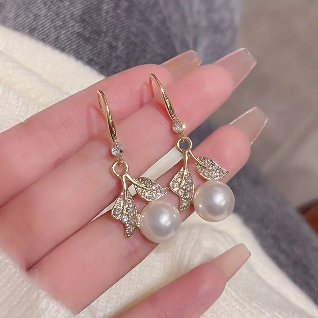close up of gold leaf pearl drop earrings detail