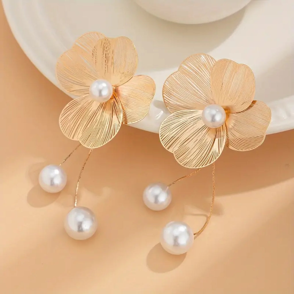 woman wearing gold flower drop earrings outfit