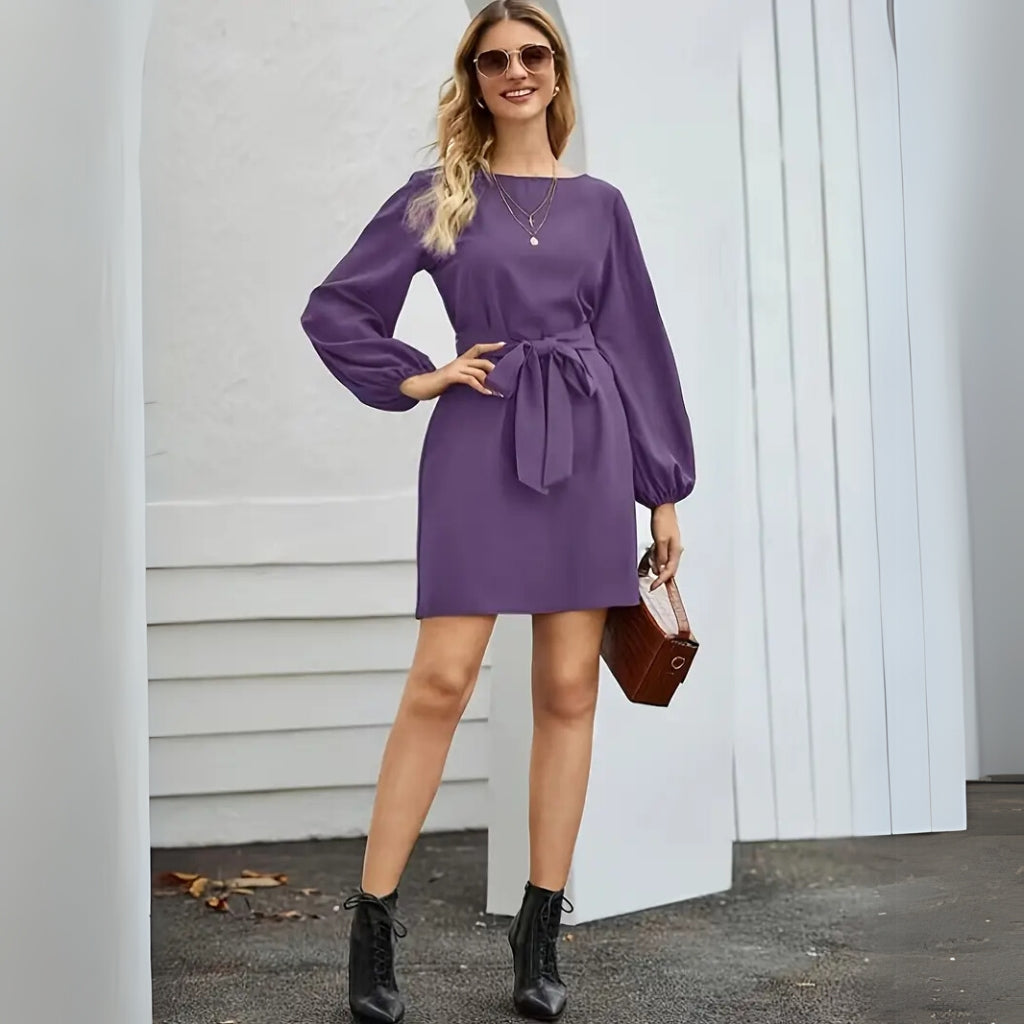 Woman wearing a long sleeve mini dress with waist tie