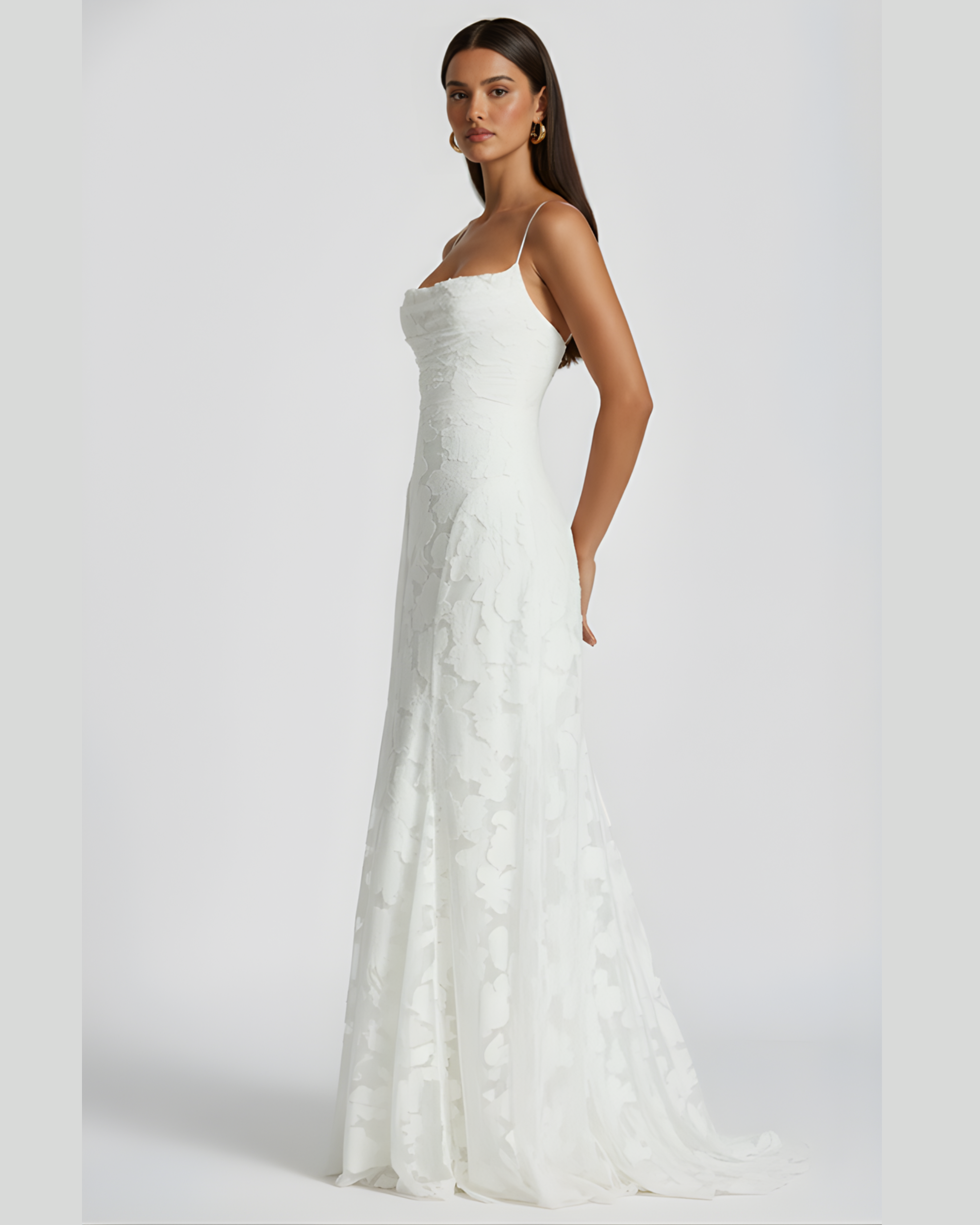 Woman wearing a white strapless gown against a plain background